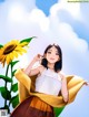 A woman standing next to a sunflower in a field.