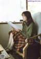 A woman sitting in a chair reading a piece of paper.