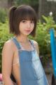 A young woman in a denim dress posing for a picture.