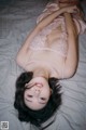 A woman laying on a bed in a pink lingerie.